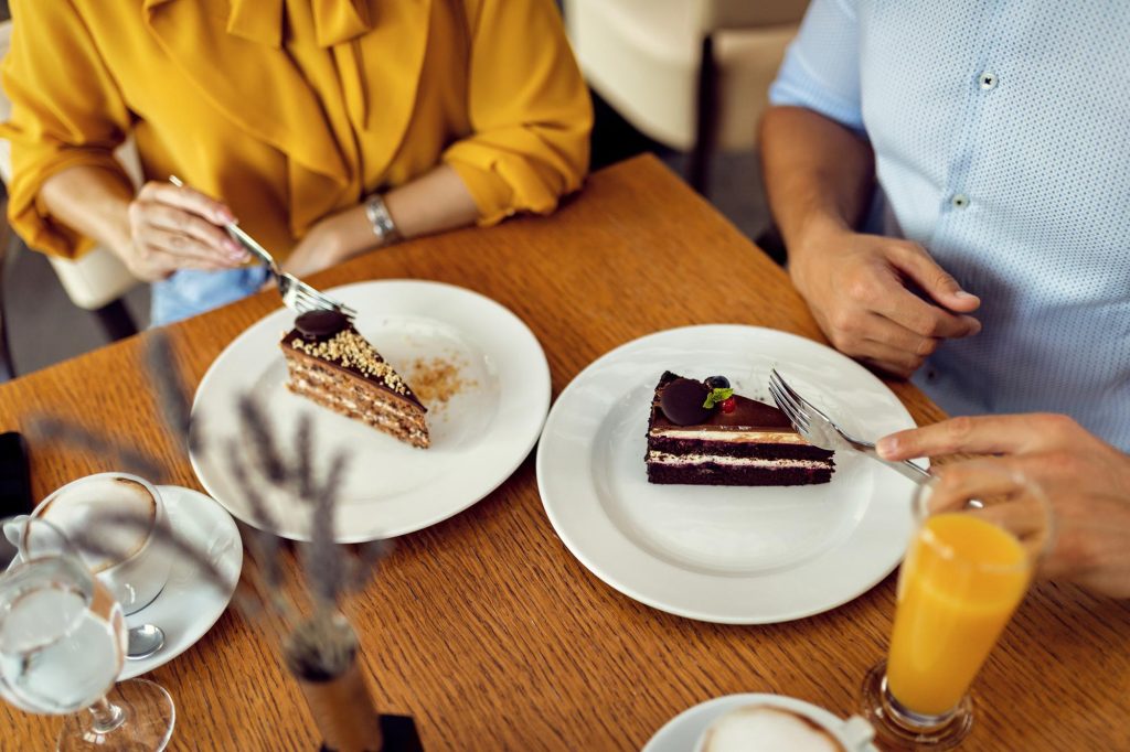 closeup-couple-having-slice-cake-dessert-cafe
