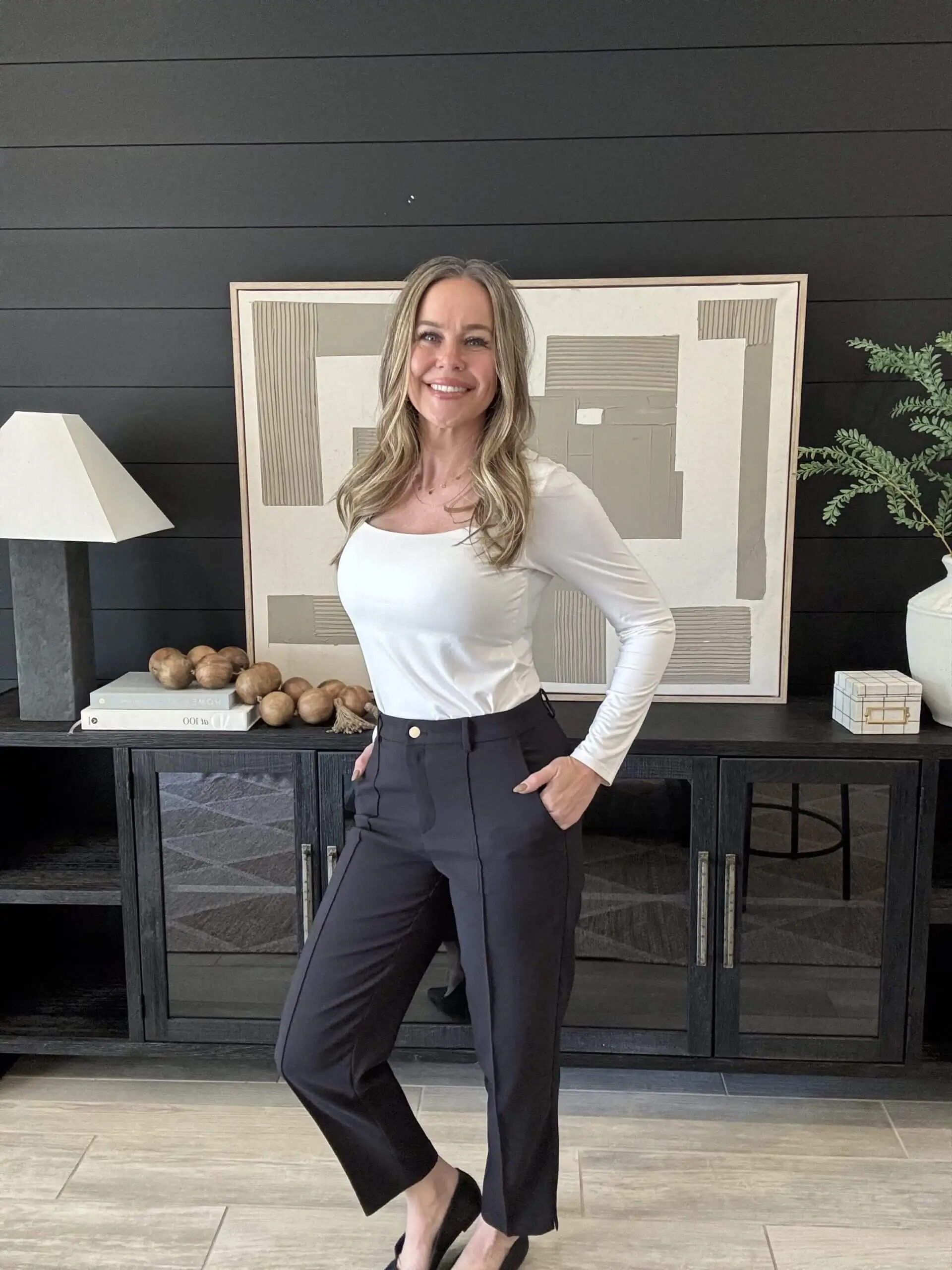 Smiling woman standing in stylish modern room.